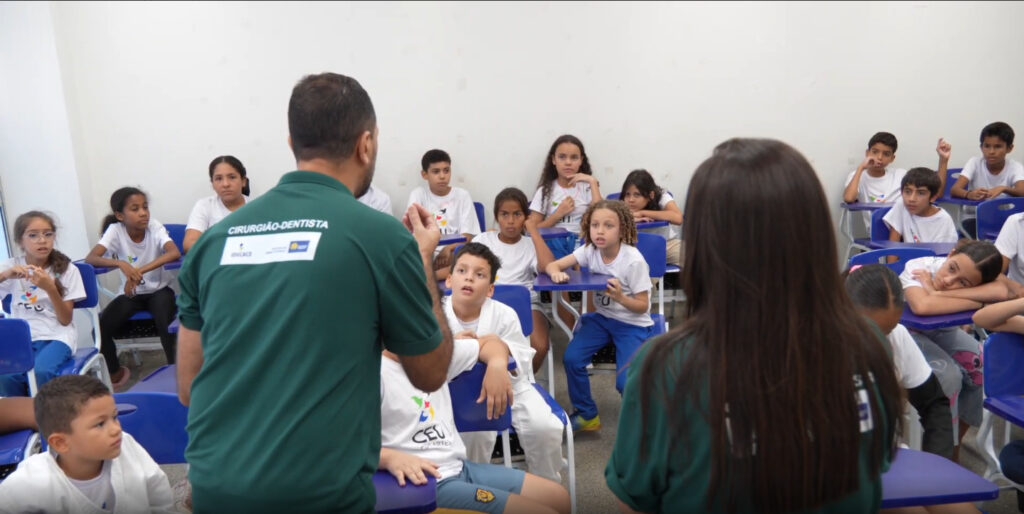 Programa DNA do Brasil propõe novo modelo de gestão pública integrada com foco em dados e desenvolvimento humano Iniciativa testada no Distrito Federal aposta na articulação entre educação, saúde e assistência social para fortalecer políticas públicas nos territórios A integração entre áreas estratégicas e o uso qualificado de dados têm ganhado espaço nas discussões sobre eficiência na gestão pública no Brasil. O tema esteve no centro do seminário do Programa DNA do Brasil – Saúde na Escola, realizado em abril, em Brasília, reunindo gestores, especialistas e representantes institucionais para debater caminhos mais estruturados para o desenvolvimento humano no país. O encontro discutiu a necessidade de ampliar a articulação entre educação, saúde, assistência social e justiça, com foco em ações coordenadas e baseadas em indicadores. É nesse contexto que o Programa DNA do Brasil – Saúde na Escola vem sendo apresentado como uma alternativa prática para fortalecer a gestão pública integrada. A metodologia, desenvolvida a partir de experiências consolidadas no esporte educacional, hoje funciona como uma plataforma voltada ao planejamento, monitoramento e qualificação de políticas públicas, alinhada a instrumentos nacionais como SAEB, IDEB, FUNDEB, VAAR e às diretrizes do Programa Saúde na Escola. O modelo reúne tecnologia, monitoramento contínuo e leitura territorial para mapear demandas específicas de cada localidade. A proposta permite antecipar necessidades e direcionar ações preventivas em áreas como saúde bucal, aspectos psicossociais e projeto de vida de estudantes. Para Wilson Cardoso, presidente do IDECACE, o desafio está em superar a fragmentação entre diferentes setores da administração pública. "É preciso avançar para uma gestão pública orientada por evidências e capaz de conectar diferentes áreas em torno de objetivos comuns. O Programa DNA do Brasil nasce justamente com esse propósito", afirma. Além do diagnóstico e acompanhamento técnico, a iniciativa investe na formação de profissionais que atuam diretamente na execução das políticas públicas. O objetivo é fortalecer a atuação local, ampliar o diálogo entre equipes e qualificar a tomada de decisão. Experiência no Distrito Federal impulsiona expansão O Distrito Federal tem sido o principal campo de implementação da metodologia, com atuação em equipamentos públicos estratégicos, como os CEUs das Artes, em Ceilândia. A experiência tem servido para ajustes operacionais, avaliação de impacto e consolidação do modelo. A participação de especialistas e representantes de instituições como o Fundo Nacional de Desenvolvimento da Educação durante o seminário reforçou a discussão sobre o papel dos indicadores na formulação de políticas públicas mais eficientes. Com mais de duas décadas de atuação e impacto direto sobre mais de 350 mil crianças e adolescentes, o IDECACE, responsável pela construção metodológica do programa, trabalha agora na ampliação nacional da iniciativa. A proposta é consolidar um modelo de gestão pública baseado em integração, prevenção e uso estratégico de dados, com potencial de aplicação em diferentes territórios do país. - Créditos da foto: Divulgação